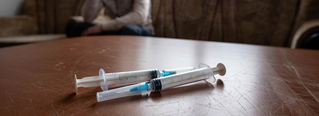 Наркотическая зависимость На столе лежат шприцы
