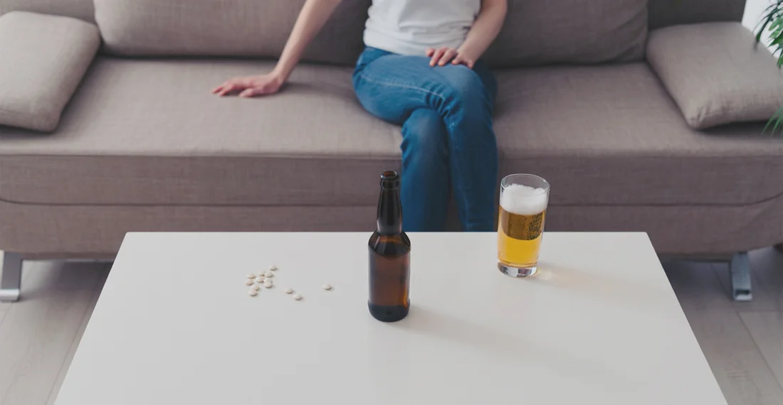 На столе бокал с пивом, бутылка и таблетки